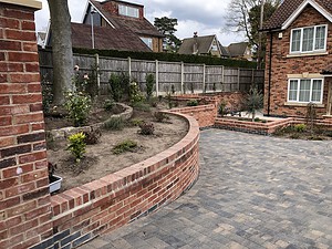curved brick walling and stone tiled driveway