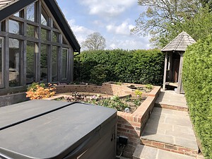 old brick built flower beds and round seating area for entertaining