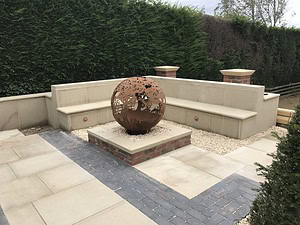 stone patio with built in seating and decorative wood burner