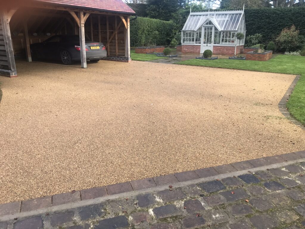 buff-stone resin driveway and timber car porch