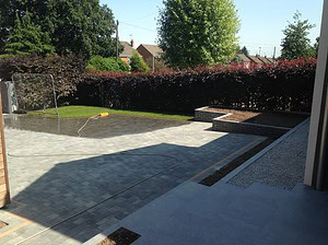 stone tiled driveway at front of house and raised beds